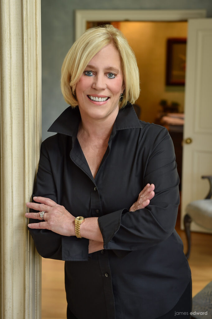 Lynn Sears smiling wearing all black, standing in a doorway